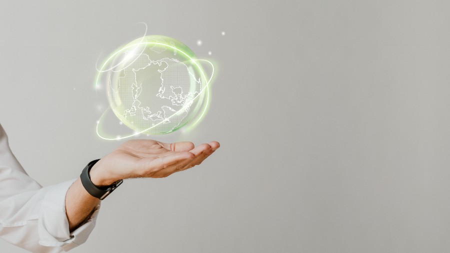 mão de uma pessoa segurando o símbolo do globo na cor verde para representar as vantagens da energia solar
