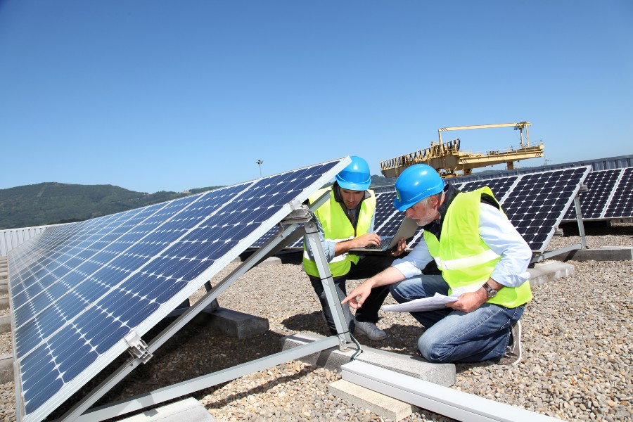 Trabalhadores instalam painéis de cooperativa de energia solar